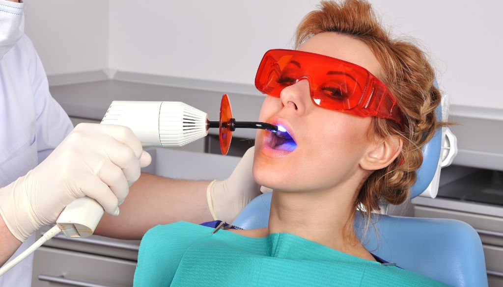 Patient undergoing laser tooth extraction, showcasing advanced techniques for laser cavity removal, laser wisdom tooth extraction, and laser tartar removal, highlighting the benefits of modern dental care.